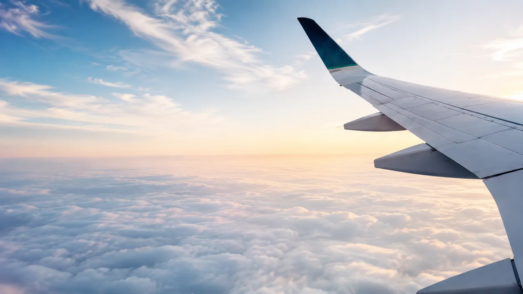 Ala de un avión sobre las nubes al atardecer